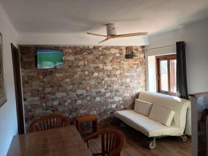 a living room with a couch and a brick wall at Casa do Marinheiro in Sesimbra