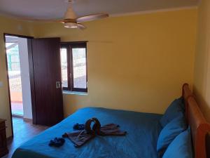 a bedroom with a bed with blue sheets and a fan at Casa do Marinheiro in Sesimbra