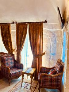 a living room with two chairs and a window at Mons Masius Hotel Teras in Midyat