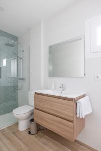 Un baño con lavabo, inodoro y espejo. en Casa Flori, en La Laguna 44 fotos más