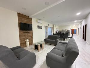 Una sala de estar con dos sofás y un comedor. en Villa Encanto Costero, en Monte Gordo