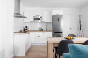 Una cocina blanca con una mesa y un refrigerador. en Casa Flori, en La Laguna
