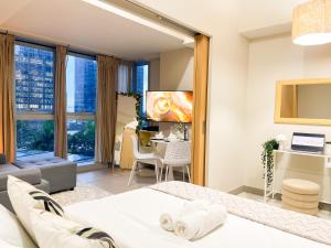 ein Schlafzimmer mit Bett und ein Wohnzimmer in der Unterkunft Prime BGC 1BR Near Mitsukoshi Mall #upt16m in Manila