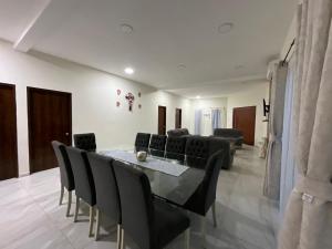 Un comedor con una mesa y sillas negras. en Villa Encanto Costero, en Monte Gordo