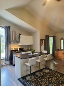 a kitchen with a counter and chairs in it at Oberge Inn Val-David in Val-David
