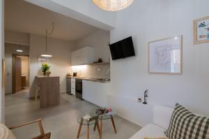 a kitchen and a living room with a table in a room at Ammos Stoupa - Cosy Casa in Stoupa