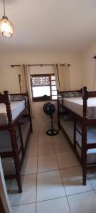 a room with three bunk beds and a window at Chácara Harmonia Pouso Alegre in Pouso Alegre
