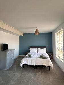a bedroom with a bed and a blue wall at Apartment in North Norfolk in Cromer