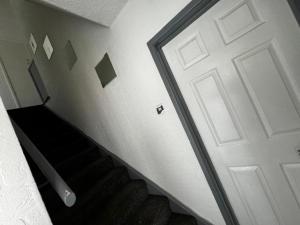 a white door in a room with a staircase at Single Room XXX Manchester in Middleton