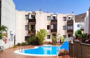 un complejo de apartamentos con piscina frente a un edificio en Casa Nature, en Playa de Santiago