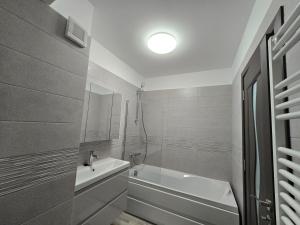 a white bathroom with a tub and a sink at Cip Apartament Tazlaului in Bacău +11 photos