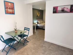 a room with a table and chairs and a bedroom at Tougang, paisible appartement in Seysses