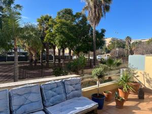 a couch sitting on a balcony with palm trees at Casa Cas in Jerez de la Frontera