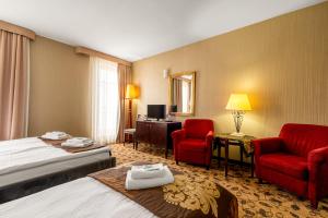 een hotelkamer met een bed en twee rode stoelen bij Great Polonia Kraków Kazimierz in Krakau +69 foto's