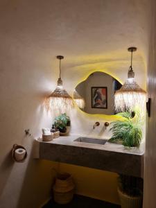 a bathroom with a sink and two pendant lights at Casa Amina in Chefchaouene