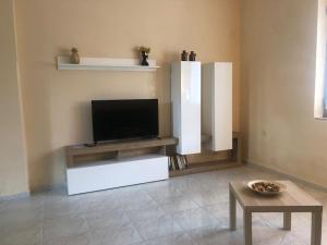 a living room with a flat screen tv and a table at CasaLotto in Reggio di Calabria