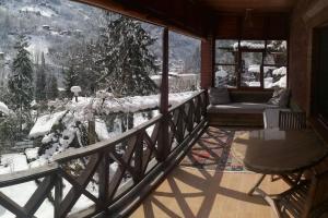 Un balcón con un sofá y una montaña cubierta de nieve. en Villa Dorchinn, en Rize