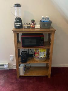 a microwave on a wooden shelf next to a blender at Apartamento en Milwaukee cerca del centro 8 mins from Milwaukee downtown in Milwaukee