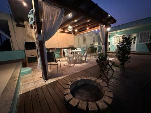 a wooden deck with a table and chairs on it at Studio completo ar e piscina in Palhoça