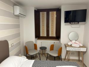 a bedroom with two chairs and a bed and a television at La Chicca di Sofy in Orvieto