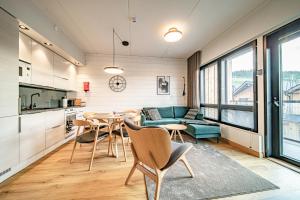 una cucina e un soggiorno con tavolo e sedie di Ski Chalet C8 Levi Center incl 2 ski passes by Aavalevi a Levi