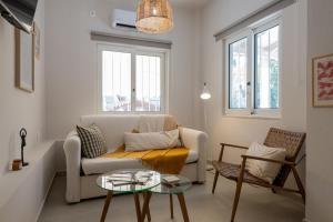 a living room with a couch and a table at Ammos Stoupa - Cosy Casa in Stoupa