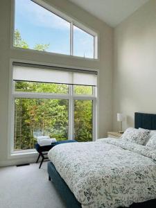 A bed or beds in a room at Whispering Pines Muskoka 3BR 3 Ensuite Baths