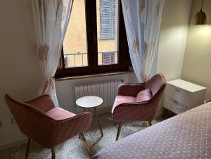 a bedroom with two chairs and a table and a window at La Chicca di Sofy in Orvieto
