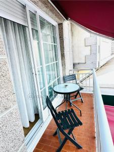 a balcony with a table and chairs and a window at CASA GLORIA - LA MAR SALADA in Combarro