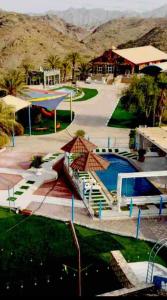 a park with a swimming pool and a building at Mountain village house in Ḑab‘ah