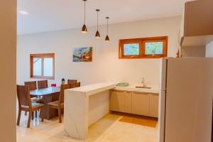 a kitchen and dining room with a table and a refrigerator at Casa Irashai in Jijoca de Jericoacoara