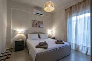 a bedroom with a bed with two towels on it at Ammos Stoupa - Cosy Casa in Stoupa