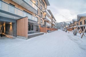 una strada innevata di fronte ad alcuni edifici di Ski Chalet C8 Levi Center incl 2 ski passes by Aavalevi a Levi