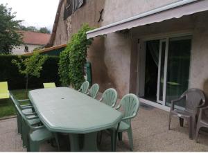 a green table and chairs sitting next to a building at Sports et détente in Fresse +4 photos