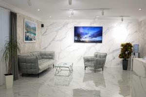 a lobby with two chairs and a couch and a table at Готель ELLING in Kropyvnytskyi