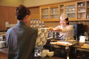 a woman is preparing food in a kitchen at Kamogawakan in Kamogawa +83 photos
