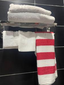a towel rack with white towels and red and white towels at Stay with Peace on Spintex road in Baatsona