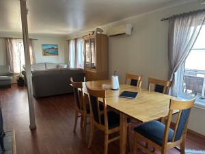 a dining room with a table and chairs and a bed at Cozy house by the sea in Tofta