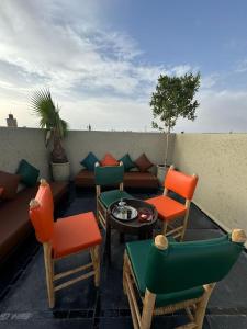a patio with chairs and a couch and a table at Riad Rodaina in Marrakech