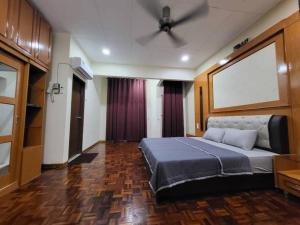 a bedroom with a bed and a ceiling fan at Aaira Guesthouse in Sungai Petani