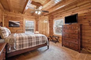 a bedroom with a bed and a flat screen tv at Bearly Behavin in Pigeon Forge