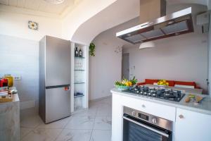 a kitchen with a stove top oven next to a refrigerator at Amalfi House Marlidia in Conca dei Marini +23 photos