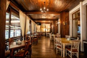 a dining room with wooden tables and chairs at Hotel Curtea Veche in Curtea de Argeş