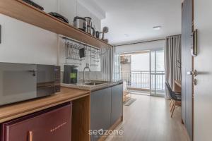 a kitchen with a sink and a microwave at Stúdio na Liberdade 270m do metrô MOL0502 in Sao Paulo