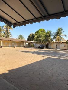 un immeuble avec des palmiers et un parking dans l'établissement Hotel Catarinense, à Sorriso