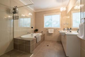 Un baño con dos lavabos, una bañera y una ducha. en Werri Big Beach House, en Gerringong 9 fotos más