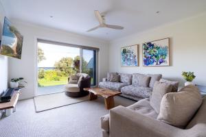 una sala de estar con un sofá y una mesa en Werri Big Beach House, en Gerringong