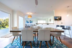 Una cocina y un comedor con mesa y sillas. en Werri Big Beach House, en Gerringong
