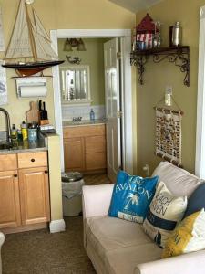 a living room with a couch and a kitchen at The Highland Cottage on Sheepscot in Edgecomb +36 photos