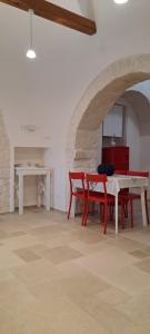 a dining room with a table and red chairs at Trullo Ritunno in Locorotondo